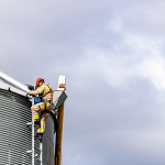 Two firefighters in PPE scaling a grain bin as part of grain bin safety training