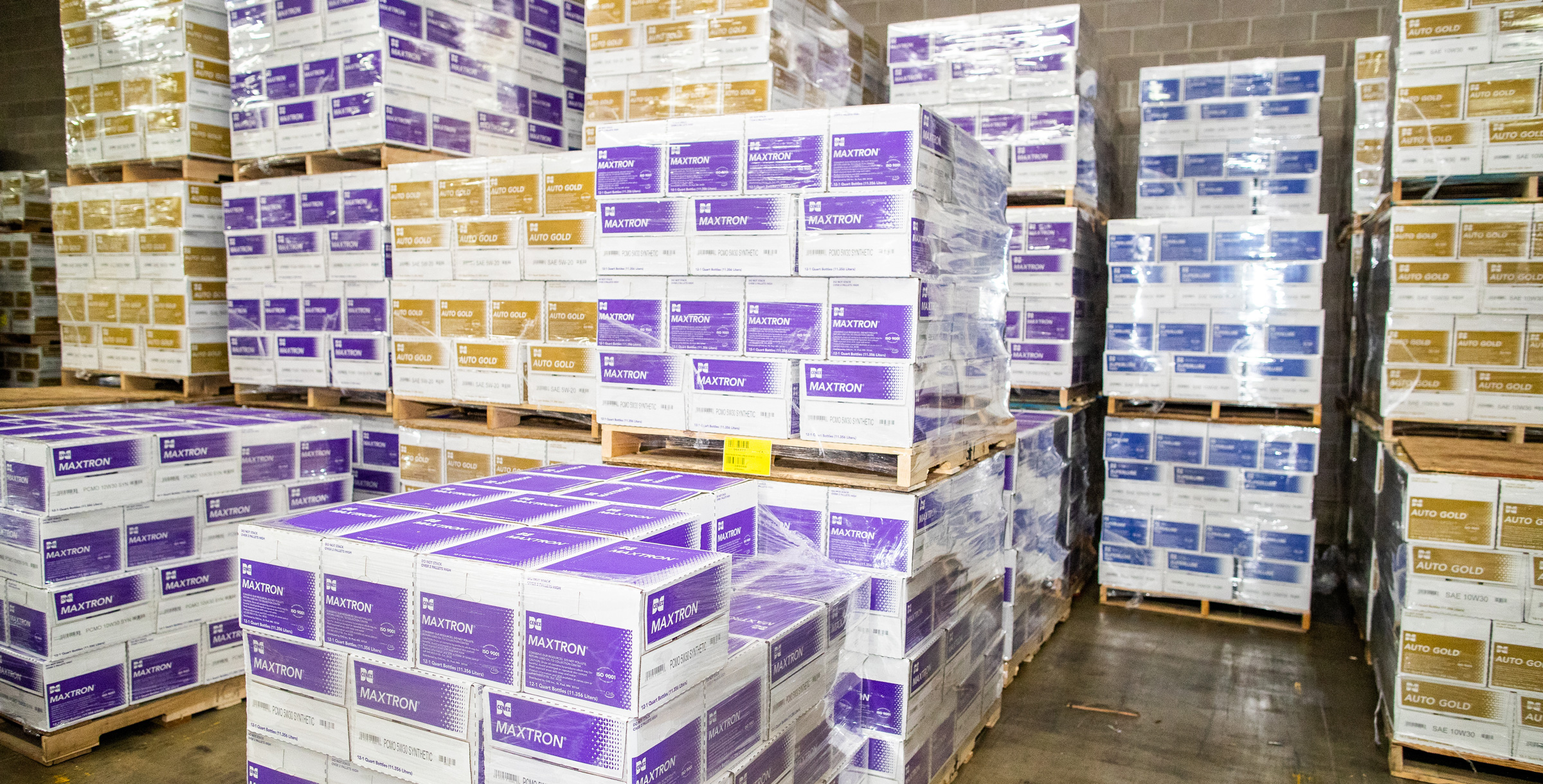 Cenex Maxtron and Auto Gold product boxes sitting on pallets in a warehouse
